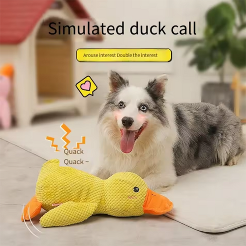 Happy dog lying beside the JMA Pet Goods plush duck dog toy with simulated duck quacking sound