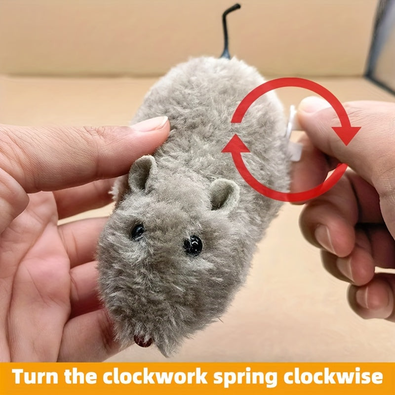 Hands winding the key on a grey JMA Pet Goods wind-up mouse cat toy, turn the clockwork spring clockwise